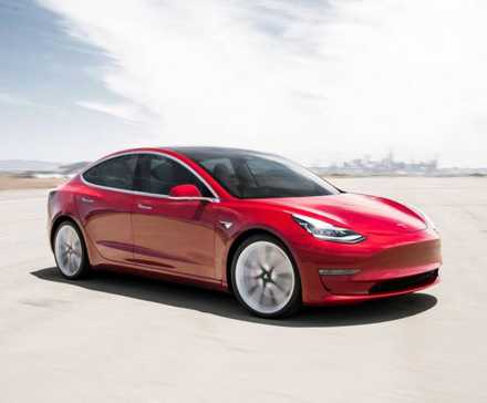 Vue complète d’une Tesla Model 3 2018 rouge roulant sur un aérodrome.