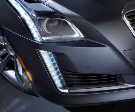 Gros plan du phare d’une Cadillac CTS 2014 grise.
