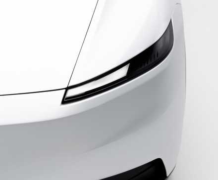 Gros plan du phare d'une Tesla Model Y Standard blanche.