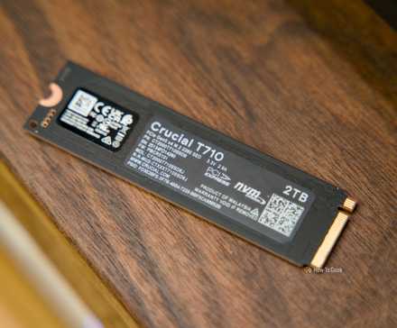 L’arrière du SSD Crucial T710 NVMe posé sur une étagère en noyer.