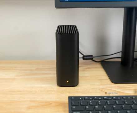 Le Synology BeeStation à côté d'un écran d'ordinateur.