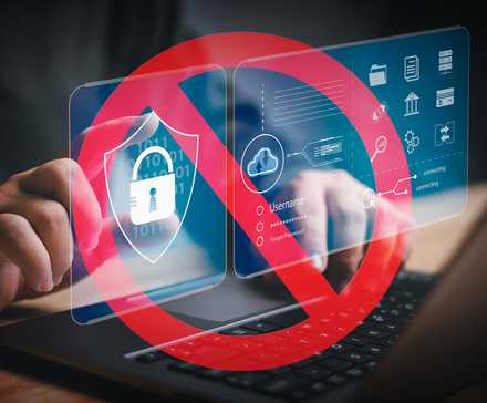 Mains tapant sur un ordinateur portable avec un panneau d'interdiction rouge sur les icônes de sécurité, indiquant une restriction d'accès numérique.