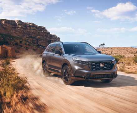 Honda CR-V Sport 2024 gris tout-terrain sur un chemin de terre.