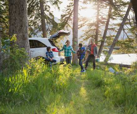 Famille déballant sa voiture dans un camping.