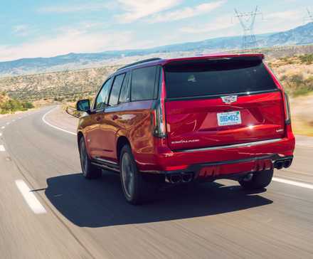 Plan 3/4 arrière dynamique d'une Cadillac Escalade-V 2023 rouge.