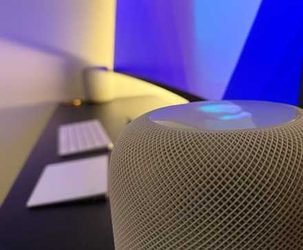 Un HomePod original en blanc sur un bureau.