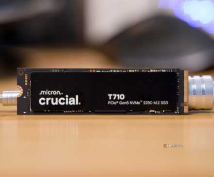 Le SSD Crucial T710 NVMe calé sur un bureau par un tournevis métallique.
