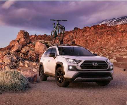 Toyota RAV4 2020 tout-terrain blanc avec un vélo sur le toit.