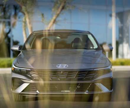 Hyundai Elantra 2026 grise garée devant un immeuble de bureaux