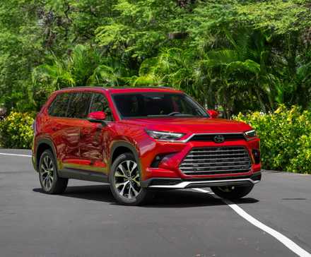 Plan statique 3/4 avant d'un Toyota Grand Highlander 2026 rouge.